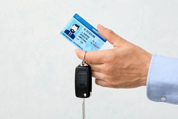 יד מחזיקה רישיון נהיגה ומפתחות רכב